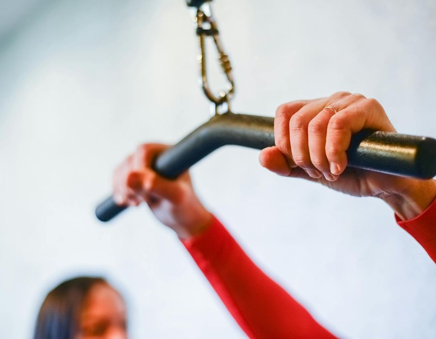Close-up of a man's hands gripping a pull-up bar firmly