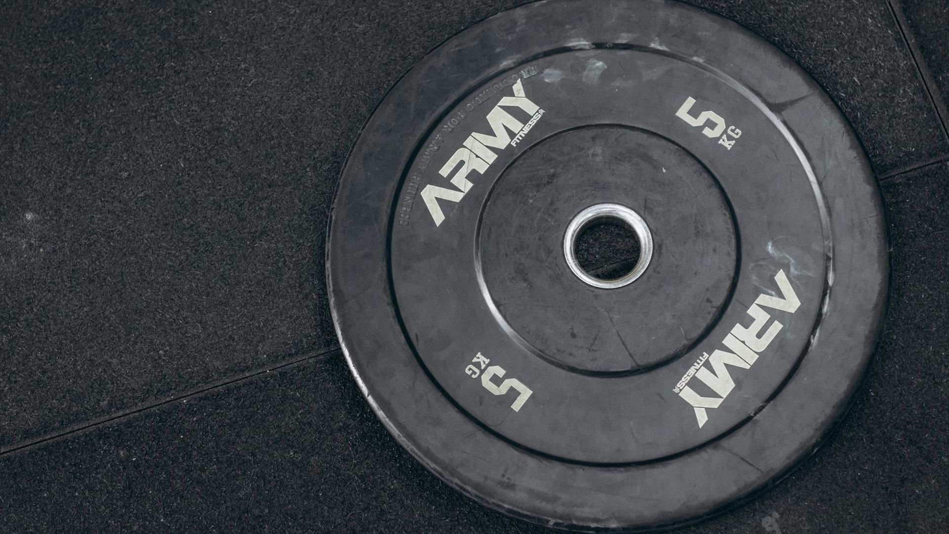 Dark gym atmosphere with heavy steel weights on the floor